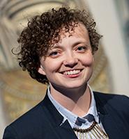 Dr. Anne Austin - smiling wearing a button down light blue shirt and dark blue blazer